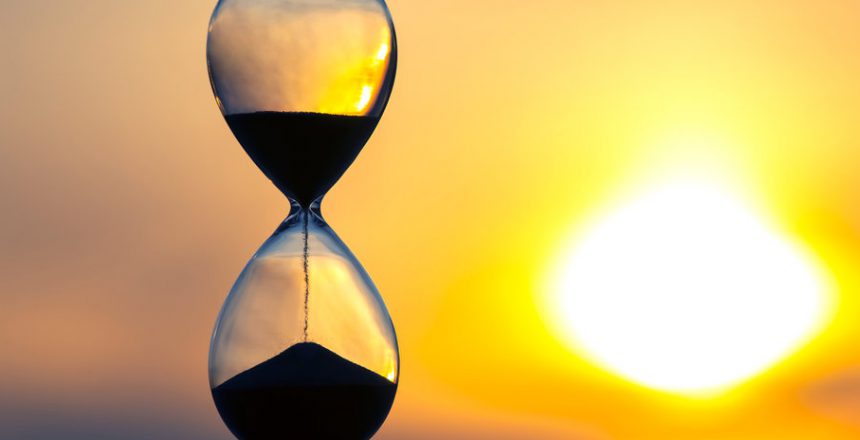 Hourglass counts the length of time against the background of the evening sun